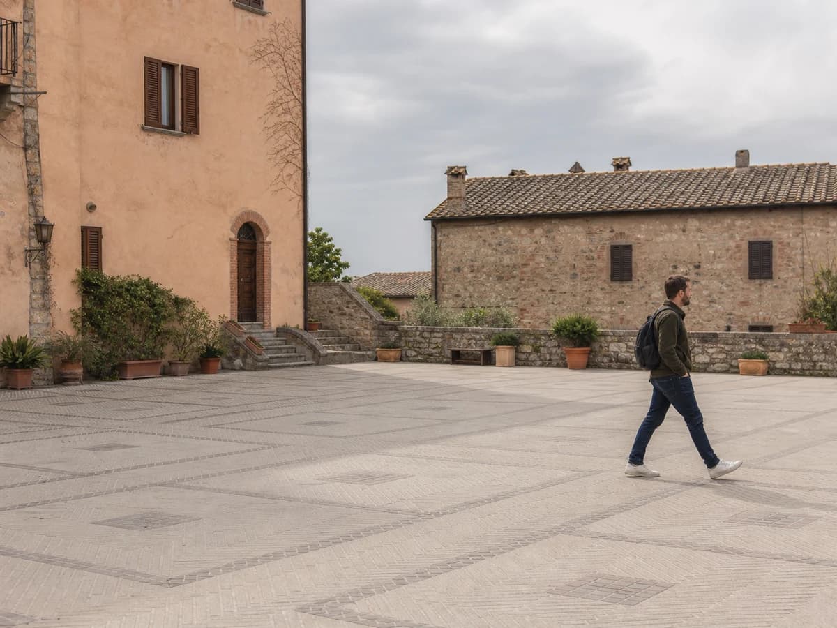 A passerby walking across a quiet stone plaza before person removal